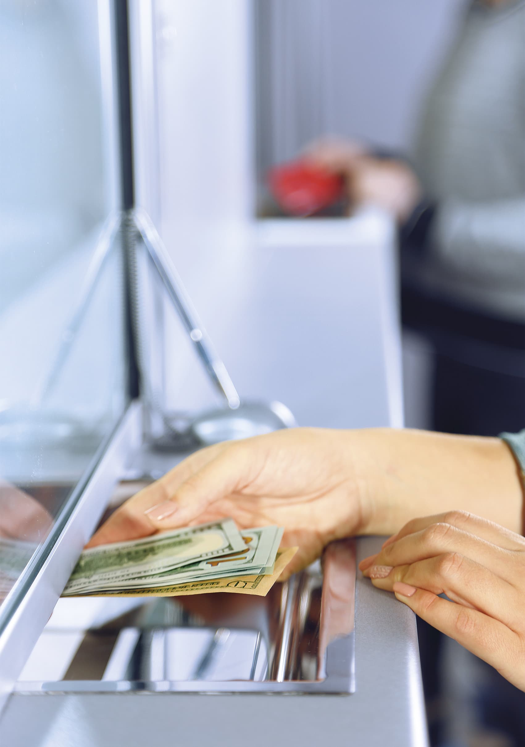 Une cliente reçoit des billets de banque au guichet.